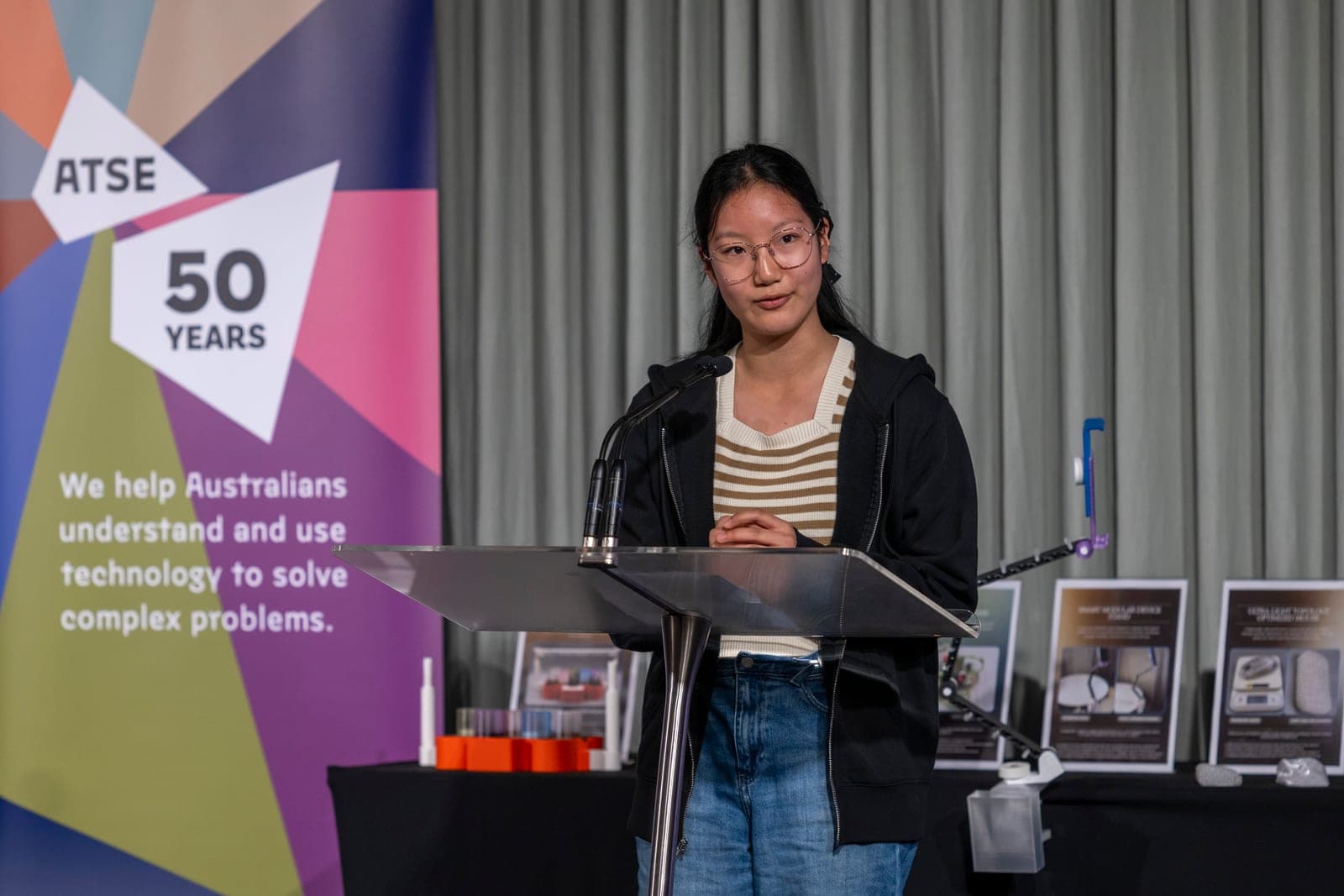A 2025 finalist presenting beside the project display table