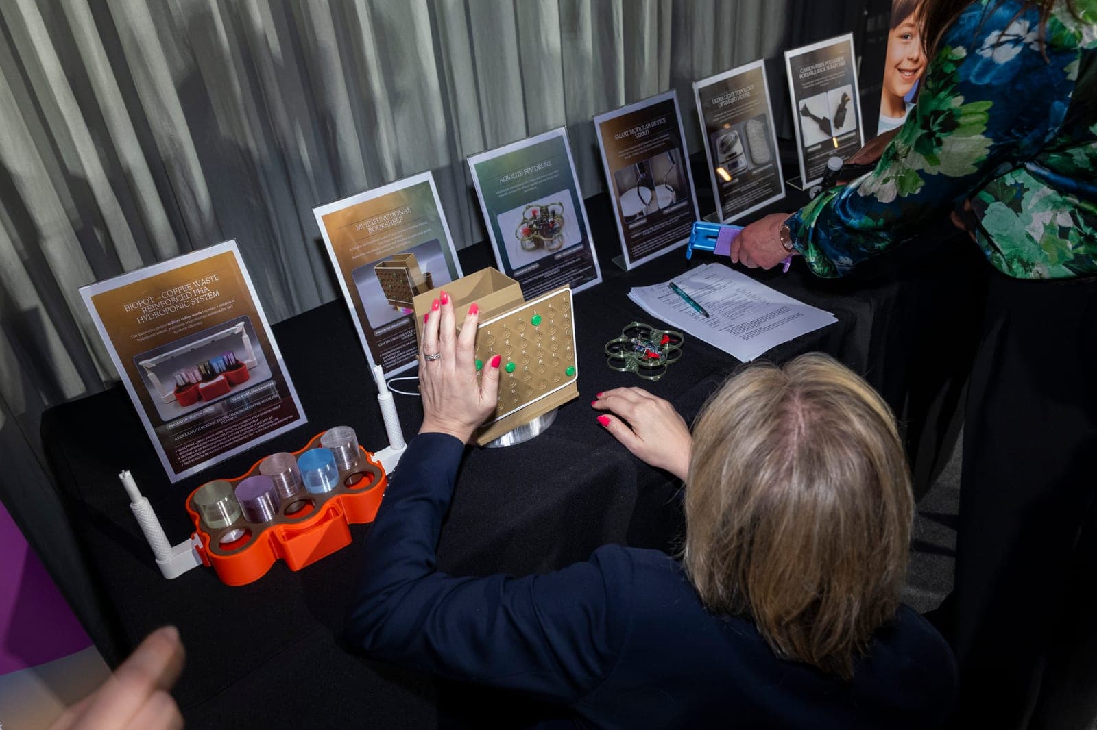 The five 2025 finalist project boards and prototypes on the Grand Final table